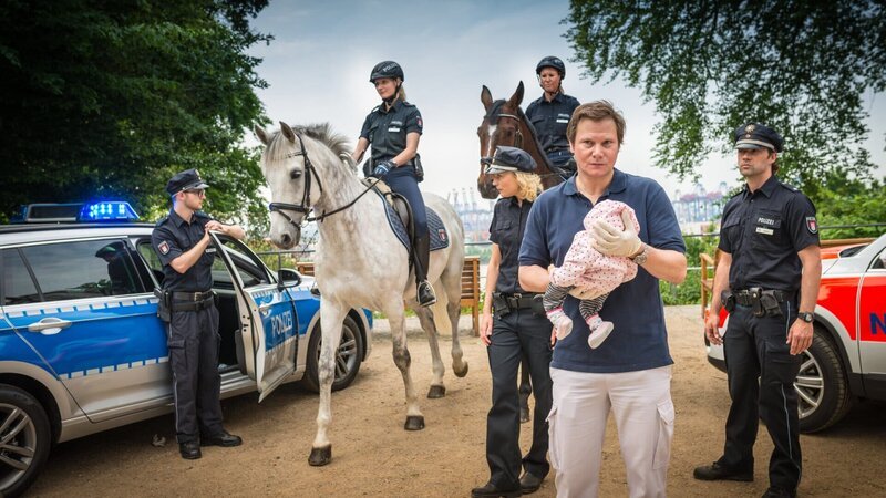 Melanie (Sanna Englund, 3.v.l.) und Mattes (Matthias Schloo, r.) haben Summer gefunden. Dr. Haase (Fabian Harloff, 2.v.r.) macht sich große Sorgen, der Säugling lag bewusstlos in seinem Kinderwagen. – Bild: Boris Laewen