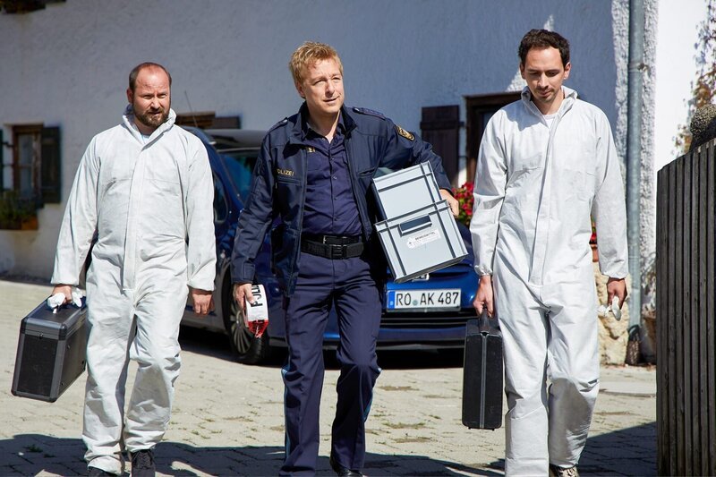 Mit Hilfe von zwei Kollegen der KTU (Komparsen) beginnt Polizeihauptmeister Mohr (Max Müller, M.), den Tatort zu sichern. – Bild: ORF/​ZDF/​Bojan Ritan