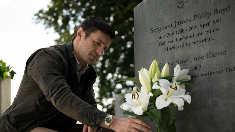 Detective Chief Inspector Philip Boyd (Eoin Macken) stellt frische Blumen auf das Grab seiner Eltern. – Bild: MARTIN MAGUIRE