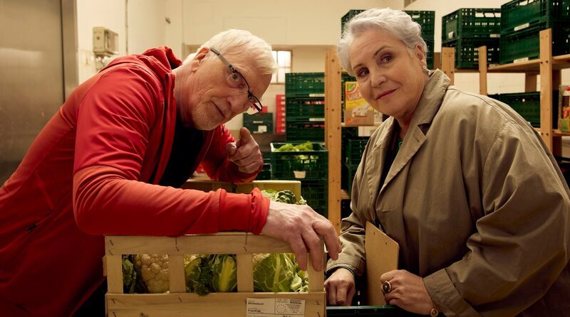 Herr Kurtz (Ernst Stötzner, li.) zeigt Anna (Katerina Jacob, re.) stolz seinen neuen Nebenjob bei der Tafel. – Bild: ARD Degeto Film/​Kai Schulz