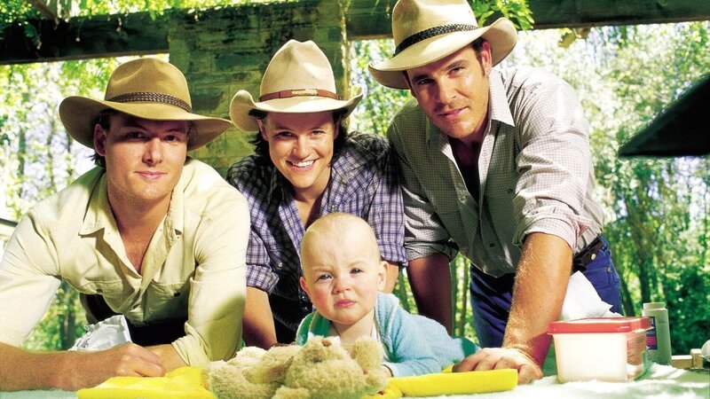 Nick (Myles Pollard), Brick (Fletcher Humphrys) und Alex (Aaron Jeffery) werden bei dem kleinen Findelkind schwach. – Bild: TVNOW /​ Southern Star