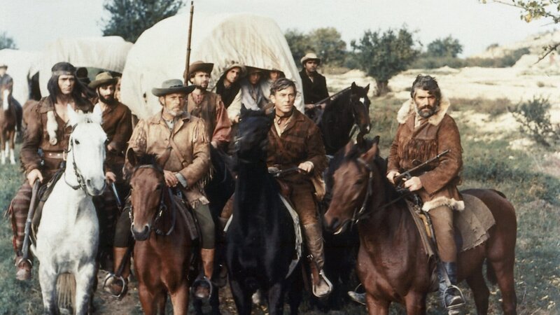 Abiram Bush (Mircea Pascu, l.), Nat Bumppo (Hellmut Lange, 2.v.l.), Miles Forman (Helmuth Schneider, 2.v.r.) und Chingachgook (Pierre Massimi, r.) beraten über den Weg des Siedlertrecks. – Bild: ZDF/​Skocrowsky/​Deropa-Franco-London