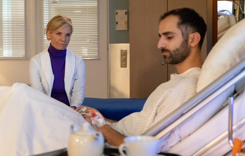 Dr. Kathrin Globisch (Andrea Kathrin Loewig) erfährt von Najim Kasem (Hadi Khanjanpour), dass er mit seinem Job seine syrische Familie finanziell unterstützt, die sein Geld dringend braucht. Das Schlimmste für ihn ist, dass die Ärzte einfach keine Ursache für seine jahrelangen Schmerzen finden. – Bild: Rudolf Wernicke