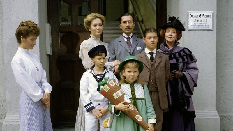 Dr. Ernst Braun (Christian Wolff), Tante Käthe (Dagmar Hessenland), Onkel Heinrich (Willy Harlander), Elsbeth (Doris Kunstmann), Frl. Hering (Wega Jahnke) sowie ihre Brüder Klaus (Florian Baier) und Hans (Oliver Schlicht) begleiten Annemarie (Kathrin Toboll) an ihrem ersten Schultag. – Bild: ZDF und Fred Lindinger/​TV 60 München