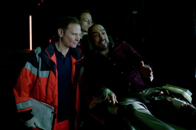 Dr. Haase (Fabian Harloff, l.) versorgt Rashid Malek (Samir Fuchs, r.), der beim Überfall auf eine illegale Pokerrunde angeschossen wurde. – Bild: Marius von Felbert /​ ZDF