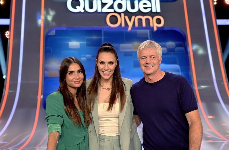 Moderatorin Esther Sedlaczek (M.) mit den Kandidaten des Teams „Sportschau“: Lea Wagner (l.) und Tom Bartels (r.). – Bild: ARD/​ITV Studios