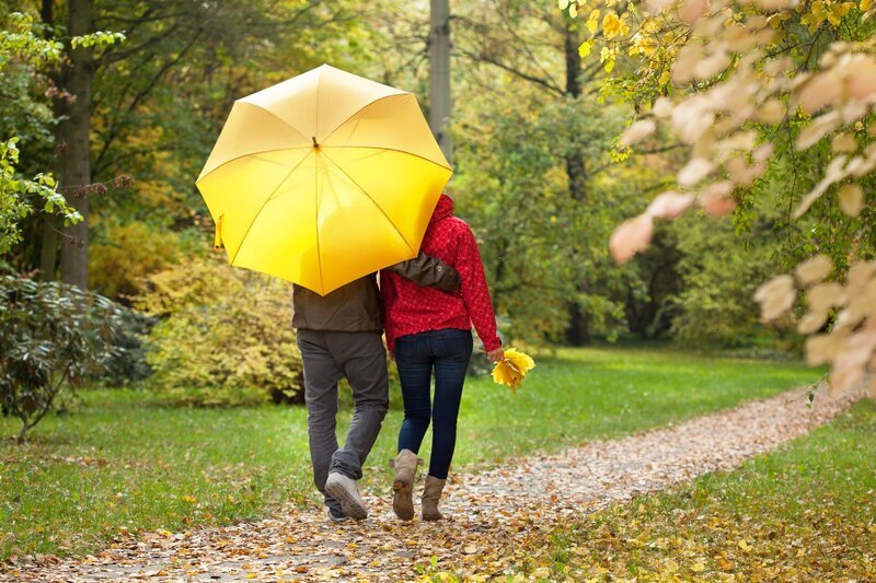 Young couple walking aroud the park under umbrella – Bild: photographee.eu