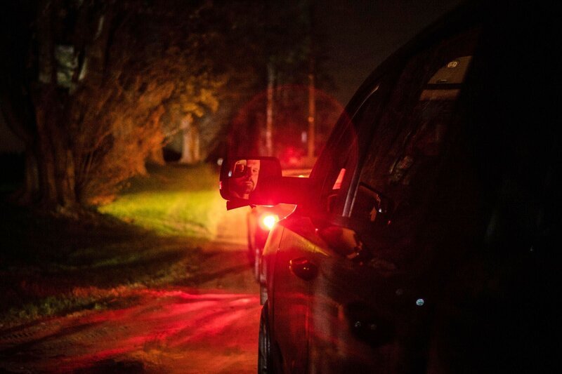 Das Spiegelbild eines Mannes im Rückspiegel eines geparkten Autos – Bild: Bad Move 6 Productions Inc /​ Crime + Investigation