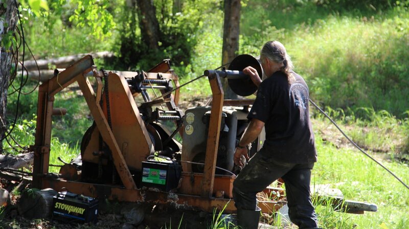 Stan Zuray works at the pulley machine that will guide the fish wheel into the river. – Bild: Discovery Communications