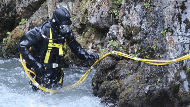 Dustin Hurt in full dive gear in shallow edge of creek. – Bild: Discovery Communications