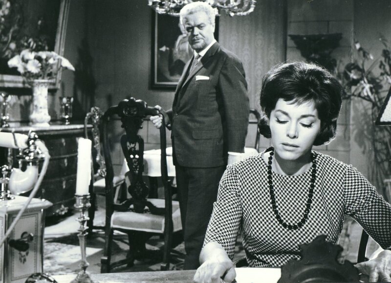 Erschüttert liest Ann Morlay (Marianne Koch), dass sich ein weiterer Frauenmord ereignet hat. Ihr Onkel Sir George Edwards (Fritz Tillmann) hat daher als Parlamentsmitglied eine Belohnung für die Ergreifung des vermeintlichen Jack the Ripper-Täters öffentlich bekannt gegeben. – Bild: CCC Filmkunst GmbH