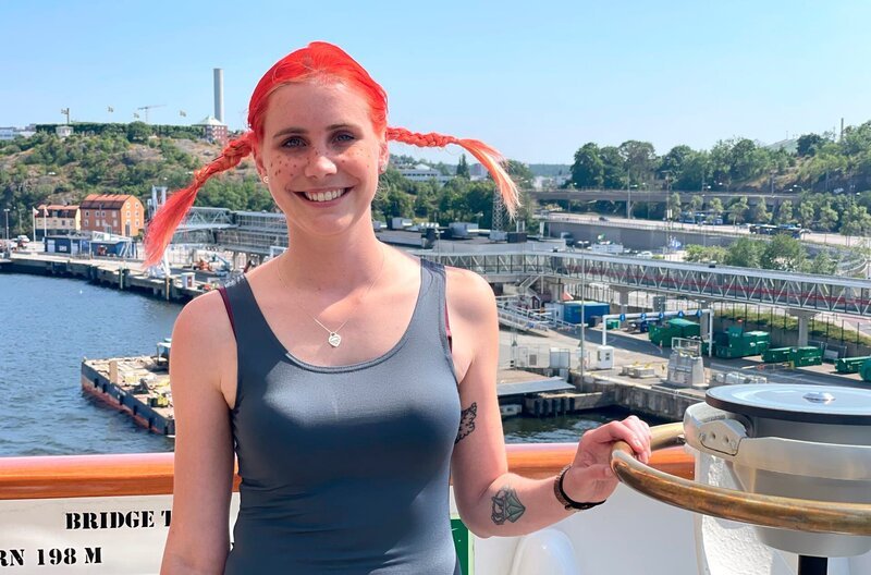Reiseleiterin Caro Sattler kommt auf die Brücke und zeigt sich im Pippi Langstrumpf-Outfit. – Bild: BR/​Bewegte Zeiten Filmproduktion GmbH/​Gerrit Mannes