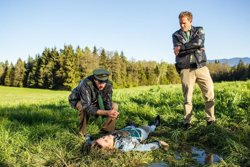 Staller (Helmfried von Lüttichau, l.) zieht die Leiche aus der Pfütze (Christian Tramitz als Franz Hubert, r.) – Bild: Leonine
