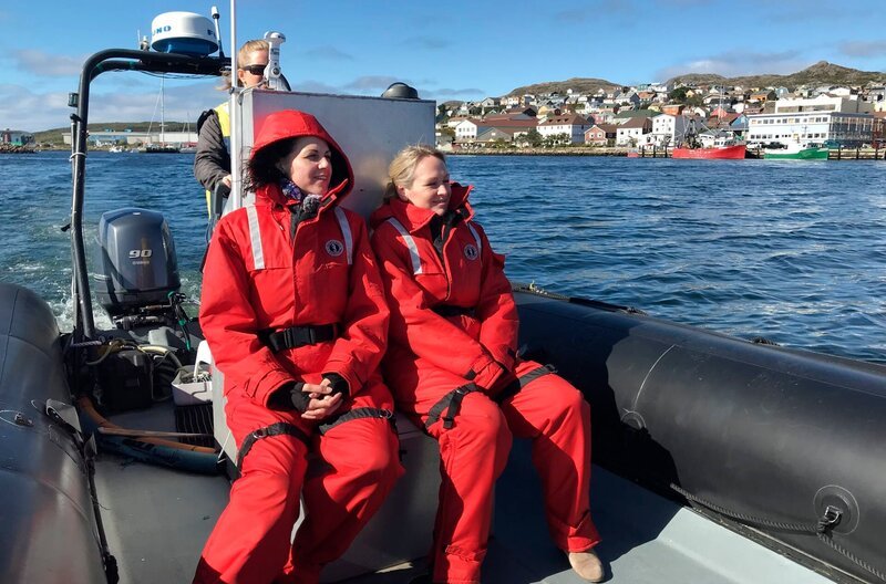 Reiseleiterin Maika Wuescher (links) und Entertainment-Managerin Corina von Wedel-Gerlach, genannt Cori, sitzen auf einem Zodiac-Boot vor St. Pierre (St. Pierre et Miquelon, französisches Übersee-Departement), wo sie eine Seehund-Kolonie besuchen. – Bild: BR/​Bewegte Zeiten Filmproduktion GmbH/​David Enge