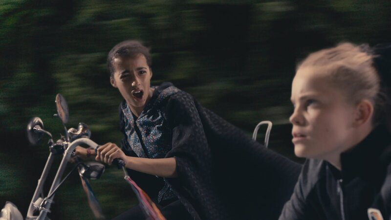 Indigo (Kelsey Calladine-Smith, l.) will Esther (Jenny Richardson) warnen. Denn sie weiß etwas, das Esther noch nicht weiß: Esther denkt nämlich, einen Schutzzaubertrank getrunken zu haben, der sie heil durch das Graustein-Rennen bringen wird. Doch dem ist nicht so, denn der Schutztaubertrank ist unwirksam, weil er gepanscht wurde. – Bild: ZDF/​CBBC/​ZDF Enterprises