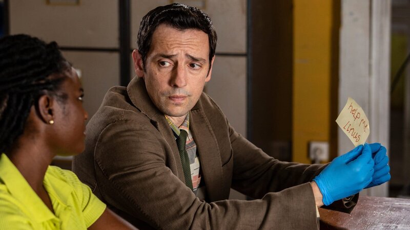 Im Polizeirevier untersuchen Naomi Thomas (Shantol Jackson, l.) und Detective Neville Parker (Ralf Little, r.) akribisch einen Zettel mit einem Hilferuf und führen entsprechende Nachforschungen durch. – Bild: Honorarfrei