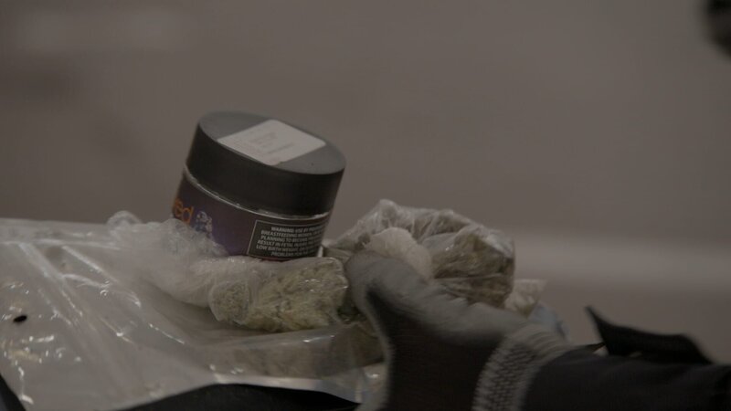 CBP-Beamter Smith hält mehrere Betäubungsmittel in der Hand, nachdem sie im Fahrzeug eines Verdächtigen entdeckt wurden, der an der Grenze falsch abgebogen war.   (National Geographic für Disney) – Bild: National Geographic for Disney /​ Disney