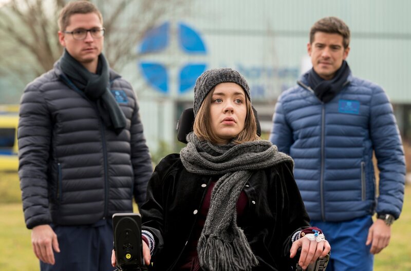 Die beiden jungen Ärzte Elias Bähr (Stefan Ruppe, l.) und Ben Ahlbeck (Philipp Danne, r.) schlagen Diana Kessler (Berenice Brause, M.) eine Operation vor, die ihr zu mehr Lebensqualität verhelfen könnte. – Bild: ARD/​Jens Ulrich Koch