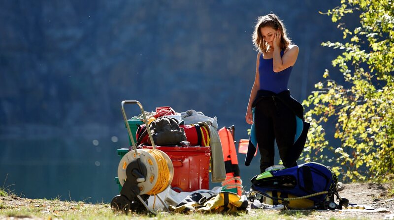 Marlene Steffens (Mathilde Bundschuh) hat eine schwere Entzündung im Ohr und striktes Verbot zu tauchen. Doch ihre Loyalität gegenüber ihrem Freund Juri und die Neugier, ob wirklich Napoleons Kriegskasse da unten im See liegt, siegen über die Vernunft. – Bild: MDR/​Maksym Lobachov