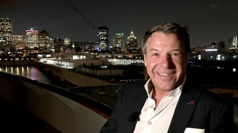 Schlagerstar Patrick Lindner, als Gastkünstler an Bord der Grand Lady von Montreal bis Halifax, posiert nachts vor der Skyline von Montreal. – Bild: BR/​Bewegte Zeiten GmbH/​David Enge