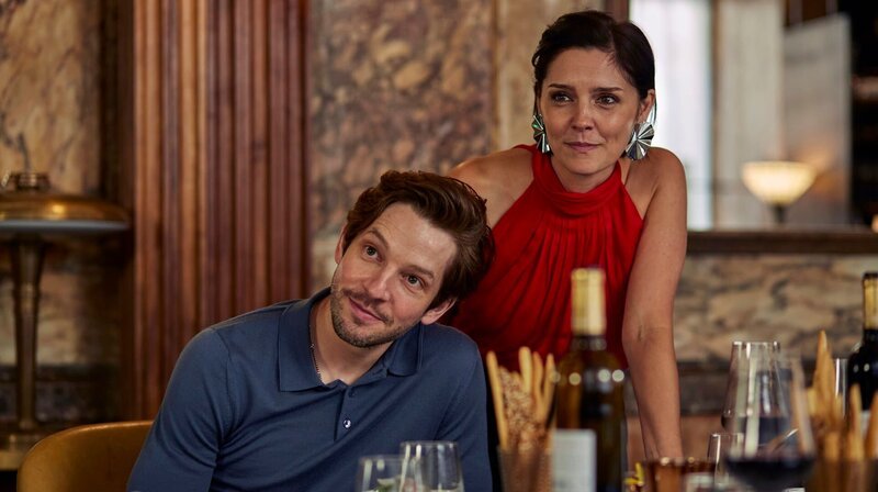 Tyler (Damien Molony, li.) und Nina (Annabel Scholey, re.) sind beim gemeinsamen Arbeitsdinner sehr vertraut. – Bild: NDR/​Sister Pictures Limited
