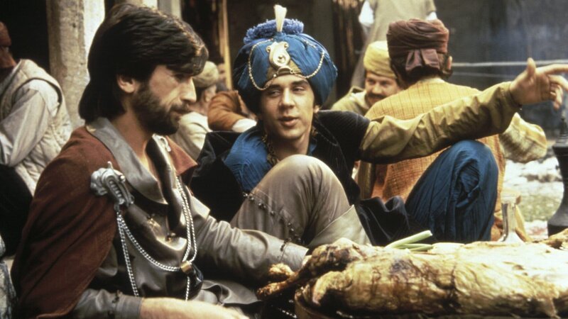 Omar (Dusan Vojnovic, l.) begegnet in einer Herberge dem Schneidergesellen Labakan (Svetislav Goncic, r.), der sich als vornehmer Herr ausgibt. – Bild: Taurus Film Omar (Dusan Vojnovic, l.) begegnet in einer Herberge dem Schneidergesellen Labakan (Svetislav Goncic, r.), der sich als vornehmer Herr ausgibt. – Bild: Taurus Film