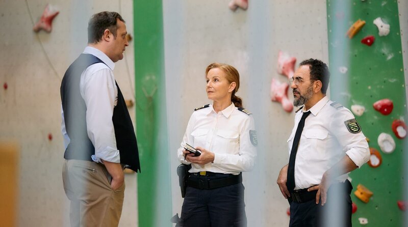 Hauptkommissarin Junghans (Carina Wiese, mi.) und Kommissar Fares (Adnan Maral, re.) befinden sich in der Kletterhalle und befragen Ben Fritsche (Andreas Merker, li.) zum Fall des toten Kletterers. – Bild: ARD/​Rudolf Wernicke