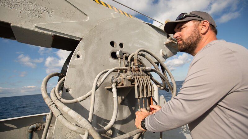 Eric Schmitt looking out into the Caribbean ocean next to crane for submarine. – Bild: Discovery Communications