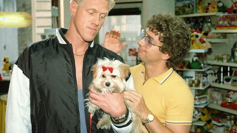Seit Harry (Norbert Heisterkamp, l.) auf Dolly, den Hund einer Freundin, aufpassen muss, sprechen ihn nur Kerle an. Atze (Atze Schröder) weiß eine Lösung: Er leiht sich den Hund für Werbezwecke aus. – Bild: MG RTL D