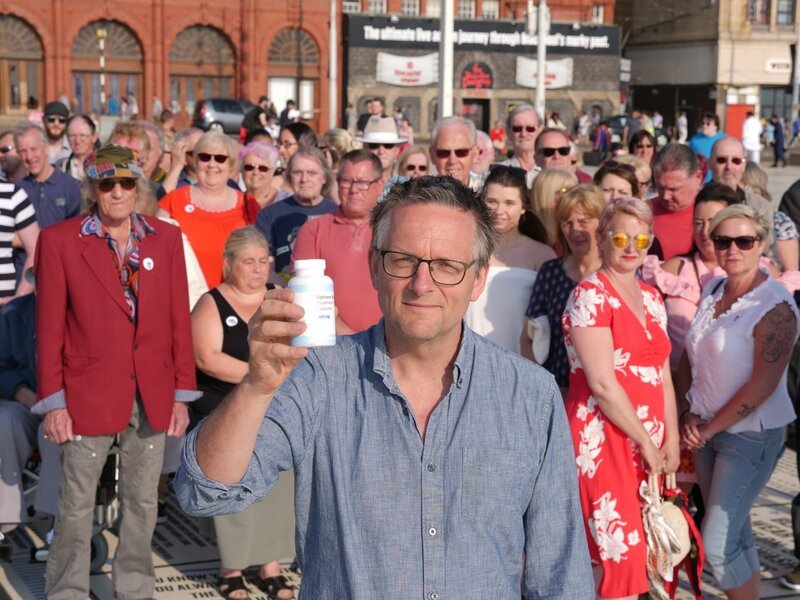 Presenter Dr. Michael Mosley mit den Freiwilligen für sein Placebo-Experiment. – Bild: BBC/​BR/​Windfall Films/​Maia Krall-Fry