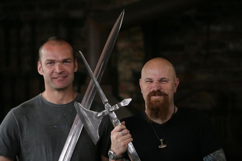 V.l.n.r.: Monty Halls und Stuart Prior halten ein Schwert und eine Poleaxt. – Bild: National Geographic