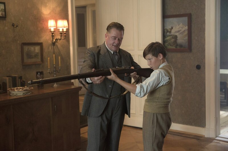 Wolter (Peter Kurth) erklärt Helgas Sohn Moritz (Ivo Pietzcker) das Gewehr. – Bild: ARD Degeto/​Beta Film/​BR/​Sky Deutschland/​X-Filme/​Frédéric Batier
