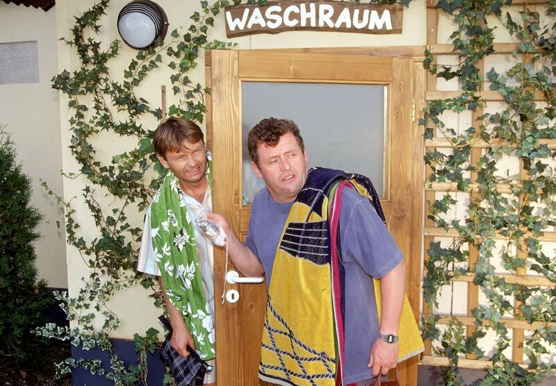 Benno (Willi Thomczyk, r.) und Lothar (Rene Heinersdorff) wollen ihre gefälschten Duschmarken ausprobieren. Noch ein schneller Blick, ob sie unbeachtet sind und dann rein ins „Badeparadies“! – Bild: RTLplus