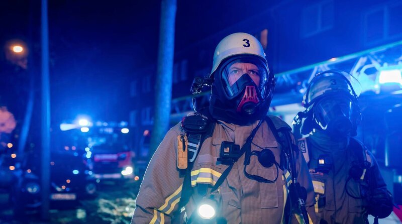 In einem Duisburger Mehrfamilienhaus breiten sich Flammen im Treppenhaus aus: Angesichts der tödlichen Gefahr durch Rauch und Feuer ist beim Eintreffen der Einsatzkräfte schnelles Handeln gefragt, um alle Menschen in Sicherheit zu bringen und das Feuer schnell zu löschen. – Bild: WDR/​Sebastian Drolshagen
