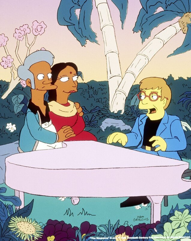 Zum Valentinstag hat Apu (l.) für Manjula (M.) Elton John (r.) eingeladen. – Bild: Twenthieth Century Fox Film Corporation