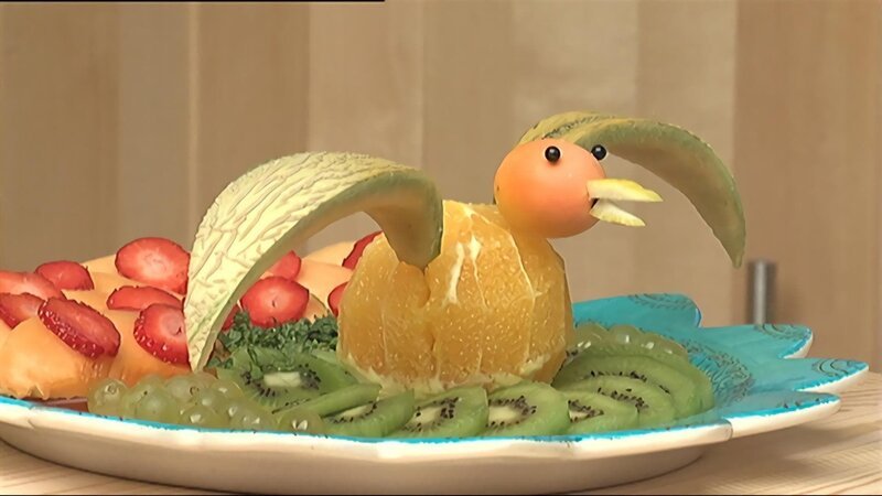 Aus viel leckerem Obst wird ein Orangenpfau mit Erdbeeraugen zubereitet. – Bild: WDR/​Die Sendung mit dem Elefanten