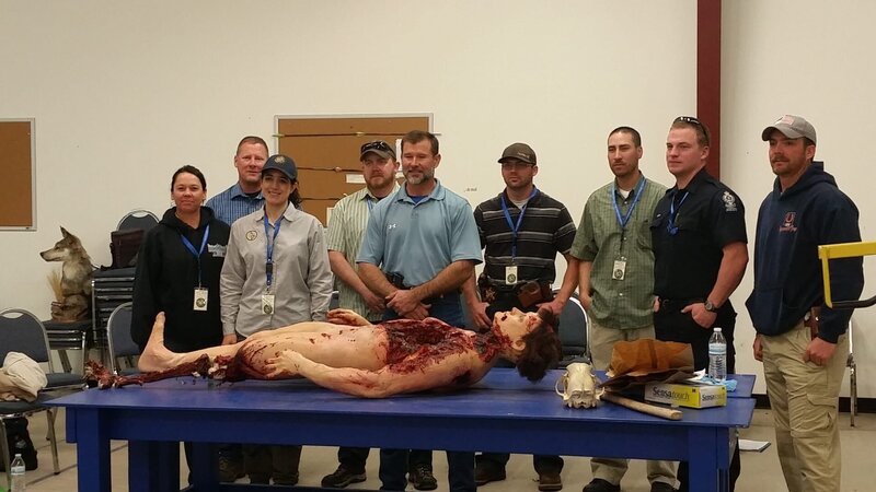 W.H.A.R.T. training classroom posing for camera with mannequin victim on table. – Bild: Discovery Communications, Inc.