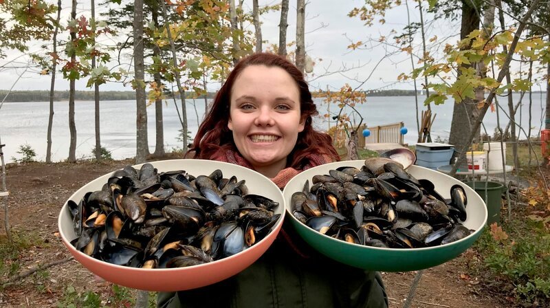 Küchenpraktikantin Steffi Gehrlein hat frische Muscheln am Strand von Saint Georges zubereitet und präsentiert sie stolz. – Bild: BR/​Bewegte Zeiten GmbH/​Gerrit Mannes