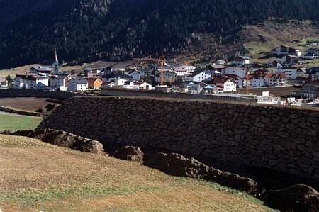 Ortschaft Galtür mit den neuerrichteten Lawinenschutzdämmen. – Bild: port.de
