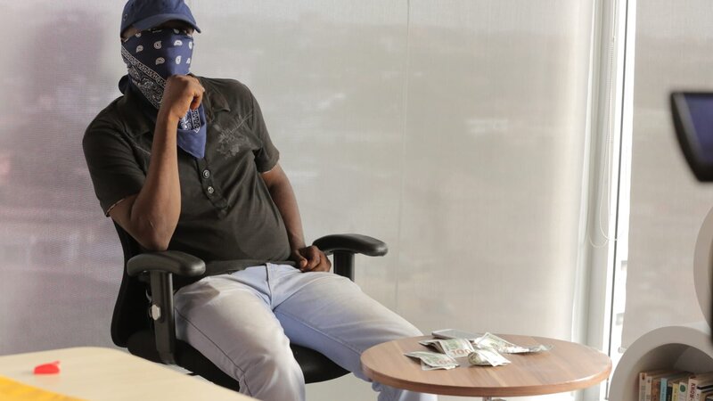 ACCRA, GHANA- „K“, ein Kokainhändler mit Geld und Drogen. – Bild: National Geographic Channels/​Laura Balfour