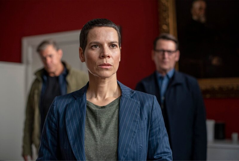 Finn (Sven Martinek, hi. li.) und Lars (Ingo Naujoks, hi. re.) statten Schuldirektorin Dorothee Schindler (Anne Düe, mi.) einen Besuch ab. – Bild: ARD/​Thorsten Jander
