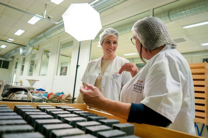 Sonja Baldauf erklärt Lisa Gadenstätter (l.) alles über die Produktion der Wiener Seife. – Bild: Neulandfilm /​ ORF