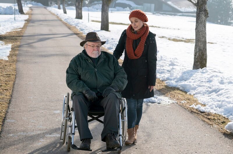 Hermann (Wolfgang Hepp) verlässt nur selten seinen Rollstuhl und lässt sich lieber von Jenny (Julia Obst) oder den anderen Familienmitgliedern durch die Gegend schieben. – Bild: SWR/​Schweigert