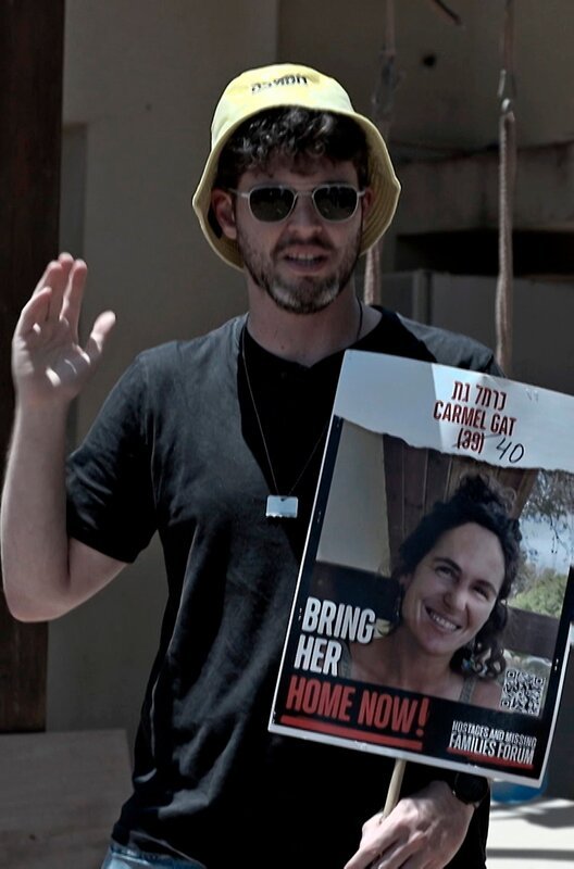 Gil Dickmann mit Poster der Hamas-Geisel Carmel Gat. Weiteres Bildmaterial finden Sie unter www.br-foto.de. – Bild: BR/Alex Goldgraber Gil Dickmann mit Poster der Hamas-Geisel Carmel Gat. Weiteres Bildmaterial finden Sie unter www.br-foto.de. – Bild: BR/Alex Goldgraber