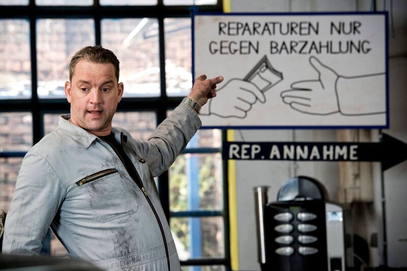 ARD/​HEITER BIS TÖDLICH – ZWISCHEN DEN ZEILEN, neue Krimi-Komödie mit 16 Folgen, Folge 12 „Homeshopping brutal“, am Donnerstag (02.05.2013) um 18:50 Uhr im Ersten. Fred (Christian Kahrmann, r.) in seiner Autowerkstatt. – Bild: ARD/​Frank Dicks