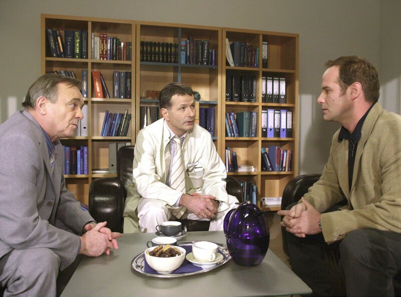 MDR Fernsehen IN ALLER FREUNDSCHAFT FOLGE 221, „Blutsbande“, Dr. Achim Kreutzer (Johannes Steck) und Dr. Roland Heilmann (Thomas Rühmann) werden zu Prof. Dr. Simoni (Dieter Bellmann) gebeten. – Bild: MDR/​Krajewski