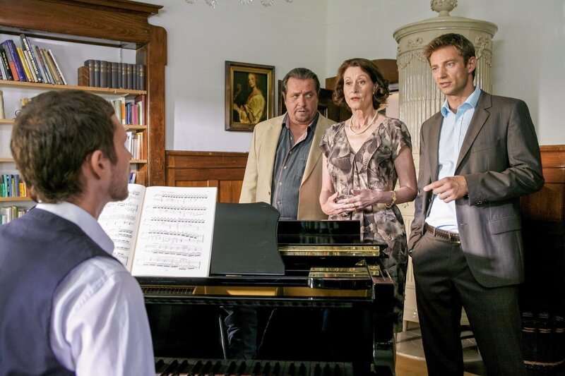 Die Rosenheim-Cops Prantl (Andreas Giebel, 2.v.l.) und Hansen (Igor Jeftic, re.) befragen Pianist Johannes Heidersberger (Julian Schmieder, li.) und seine Mutter Hildegard (Susanne Scholl, 2.v.r.) nach ihren Alibis. – Bild: ORF 2