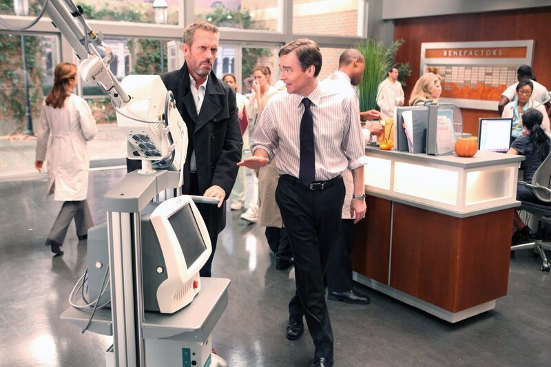 Wilson (Robert Sean Leonard, re.) fängt House (Hugh Laurie), der gerade den Laser in Foremans Büro bringen will, in der Lobby ab. – Bild: Universal Network Television LLC