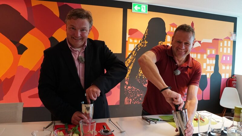 Kreuzfahrtdirektor Mirko Scheffe und Hotelmanager Rudi van Beulen lernen in der Espaco Porto Cruz mit Portwein Cocktails zu mixen. Sie sind in Porto. – Bild: Bewegte Zeiten Filmproduktion GmbH/​BR/​Deborah Stoeckle