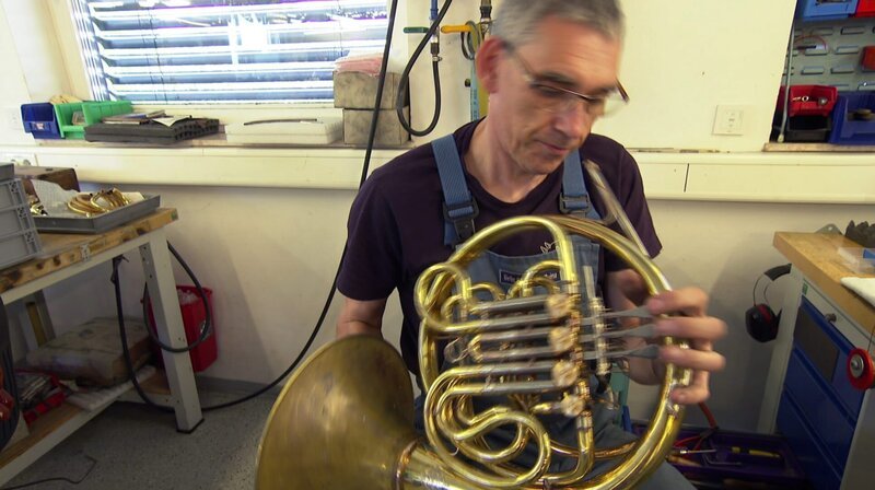 Blasinstrumentenbauer Eckard Graf prüft das von ihm gebaute Horn – Bild: SWR